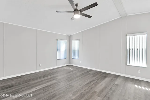a view of a big room with wooden floor and a ceiling fan