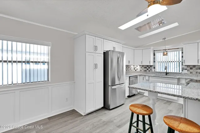 a kitchen with stainless steel appliances granite countertop a refrigerator and a stove top oven