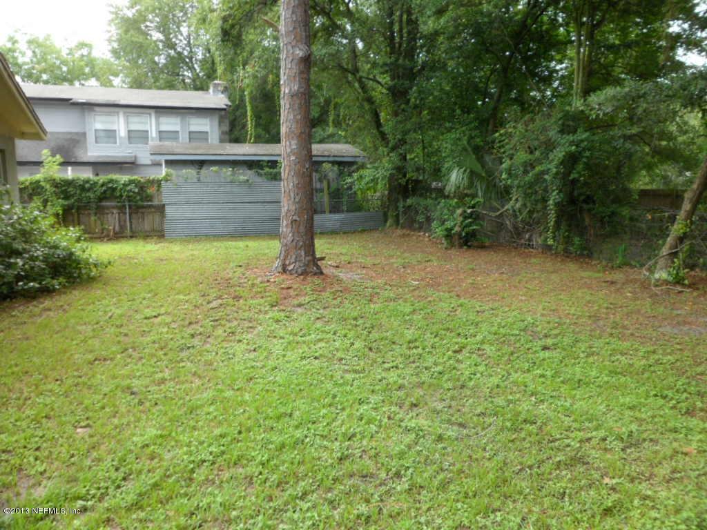 7356 Strato Road Jacksonville, FL 32210 - Photo 4 of 19 a backyard of a house with plants and large tree
