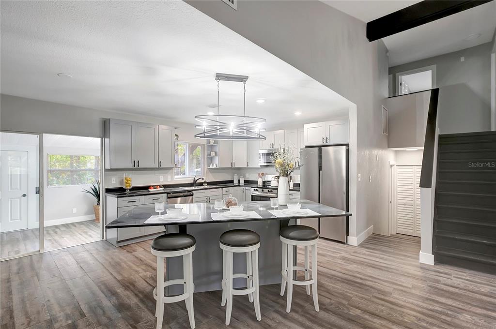 16133 Ravendale Drive Tampa, FL 33618 - Photo 12 of 46 a kitchen with stainless steel appliances kitchen island granite countertop a table chairs stove and refrigerator