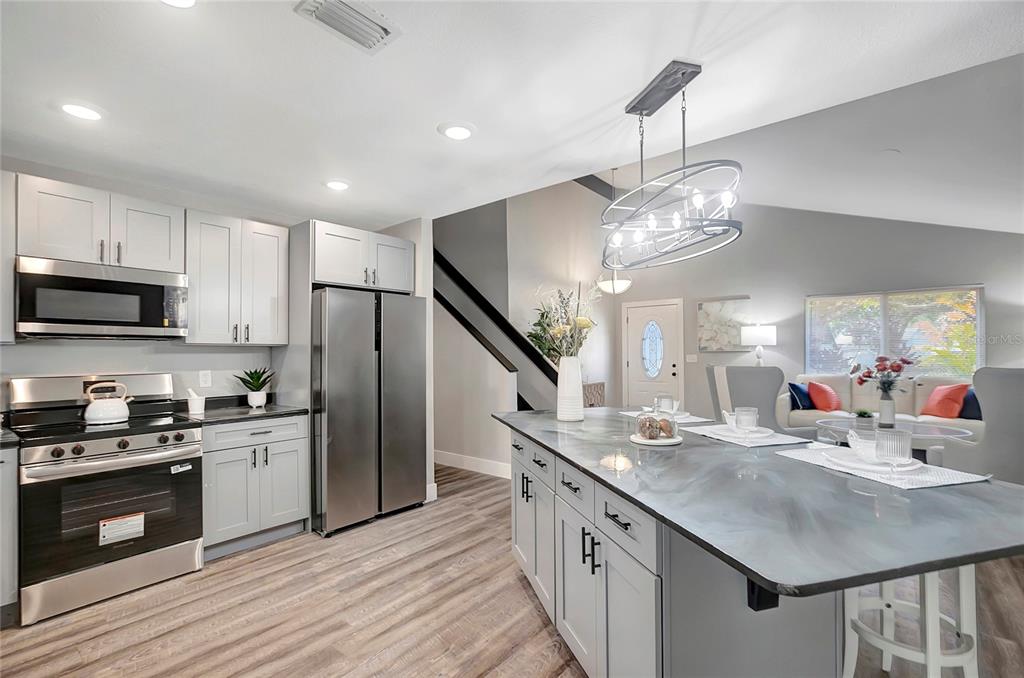 16133 Ravendale Drive Tampa, FL 33618 - Photo 15 of 46 a kitchen with stainless steel appliances granite countertop a sink stove and refrigerator