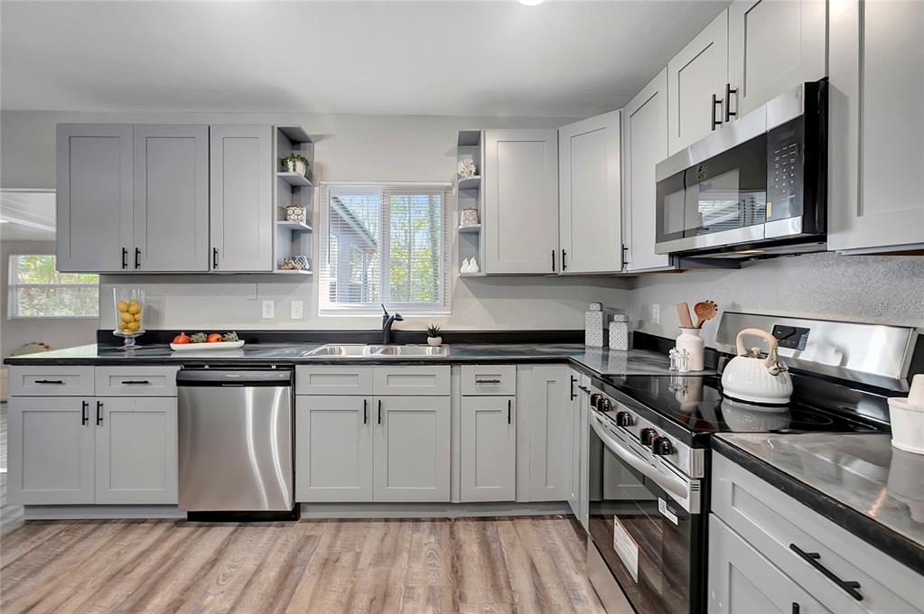 16133 Ravendale Drive Tampa, FL 33618 - Photo 17 of 46 a kitchen with stainless steel appliances granite countertop a stove a sink and a microwave