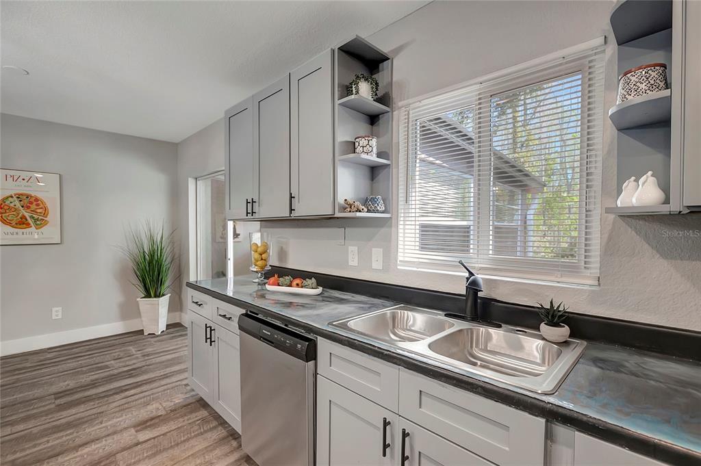 16133 Ravendale Drive Tampa, FL 33618 - Photo 19 of 46 a kitchen with stainless steel appliances granite countertop a sink a stove and a wooden floor