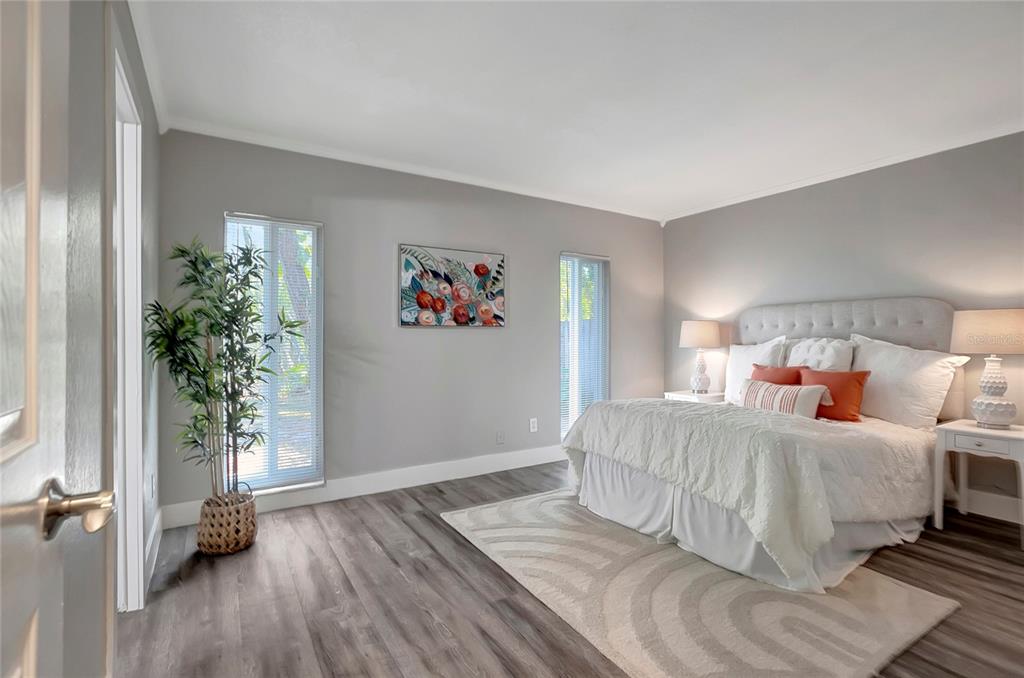 16133 Ravendale Drive Tampa, FL 33618 - Photo 23 of 46 a bedroom with a large bed and a potted plant