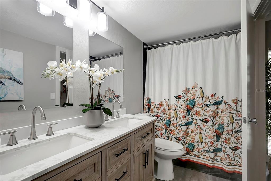 16133 Ravendale Drive Tampa, FL 33618 - Photo 27 of 46 a bathroom with a sink a mirror and a toilet