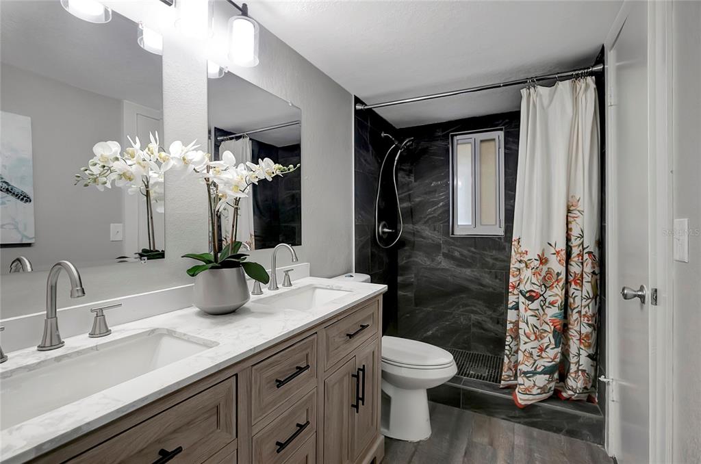 16133 Ravendale Drive Tampa, FL 33618 - Photo 28 of 46 a bathroom with a sink a toilet and a mirror