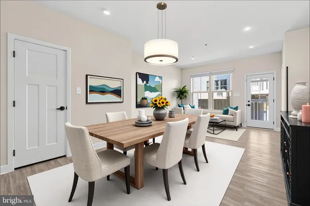 a view of a dining room and livingroom furniture wooden floor a rug and a chandelier