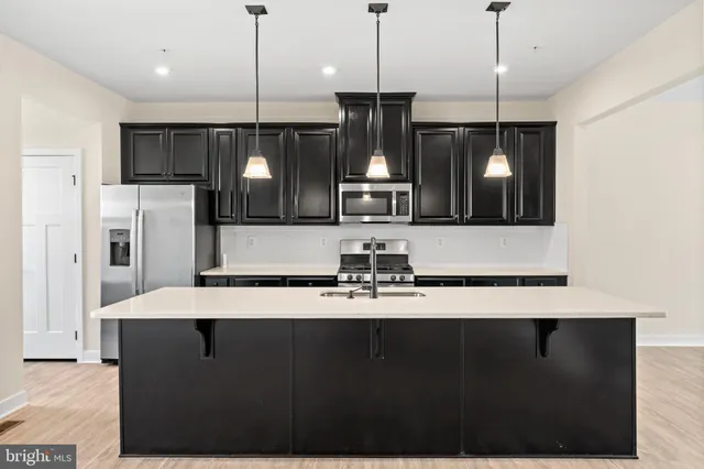 a kitchen with a refrigerator a sink and chairs