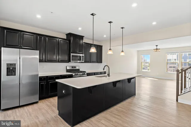 a kitchen with stainless steel appliances granite countertop a sink a stove and refrigerator