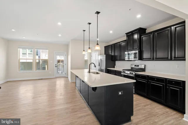 a large kitchen with stainless steel appliances kitchen island a stove and a sink