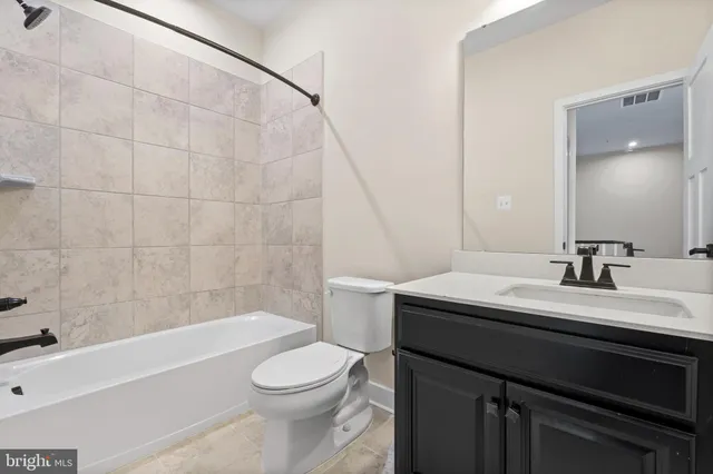 a bathroom with a sink a toilet a mirror and bathtub