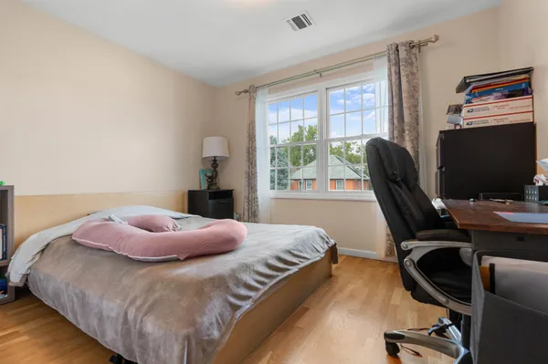 a bedroom with a bed a desk and chair with a large window