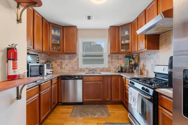 a kitchen with stainless steel appliances granite countertop a sink stove and cabinets