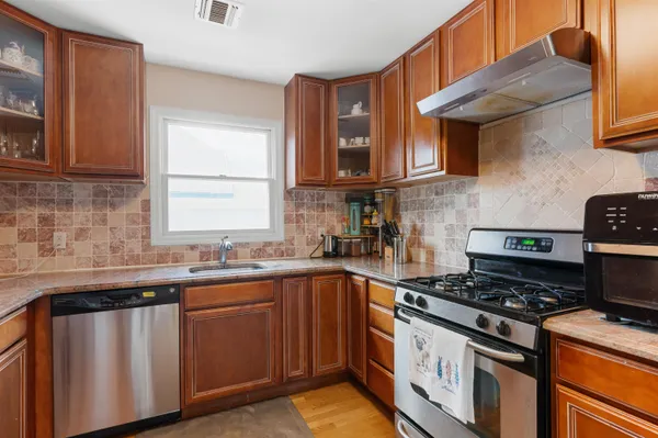 a kitchen with stainless steel appliances a sink stove and cabinets
