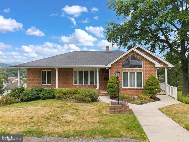 a front view of house with yard and trees around