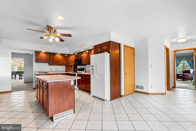 an empty room with ceiling fan and window