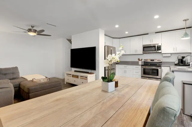 a living room with stainless steel appliances kitchen island furniture a flat screen tv and kitchen view