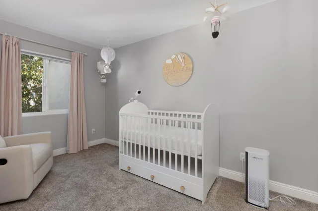 a living room with furniture and a baby crib