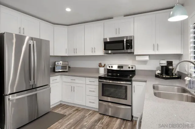 a kitchen with stainless steel appliances granite countertop a refrigerator stove a sink and microwave