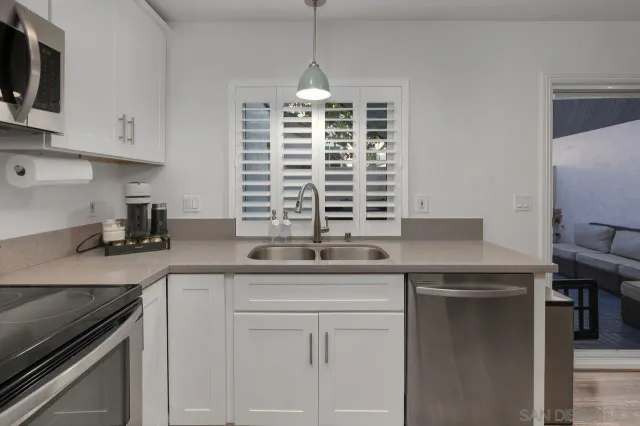 a kitchen with stainless steel appliances granite countertop a sink a stove and a microwave