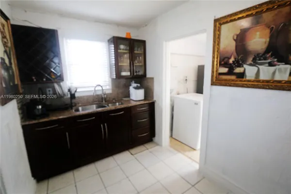 a kitchen with a refrigerator and a flat screen tv