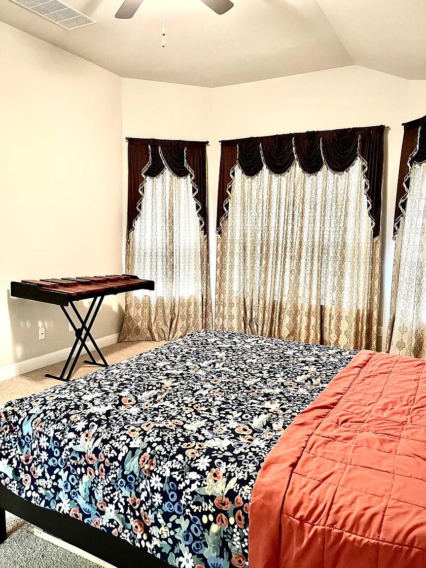 4221 Borho Ranch Street Leander, TX 78641 - Photo 13 of 16 This bedroom features wall-to-wall carpeting, a ceiling fan, and bay windows with decorative valances