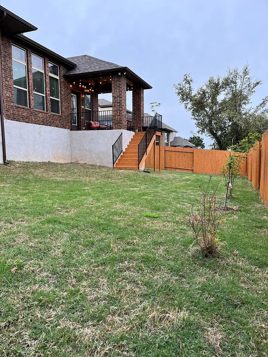 4221 Borho Ranch Street Leander, TX 78641 - Photo 16 of 16 The property features a spacious lawn, a two-story brick exterior, and a covered patio with string lights
