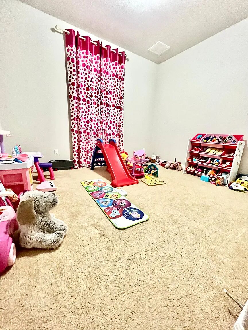 4221 Borho Ranch Street Leander, TX 78641 - Photo 8 of 16 The room features light-colored carpeting, white walls, and a window with patterned curtains