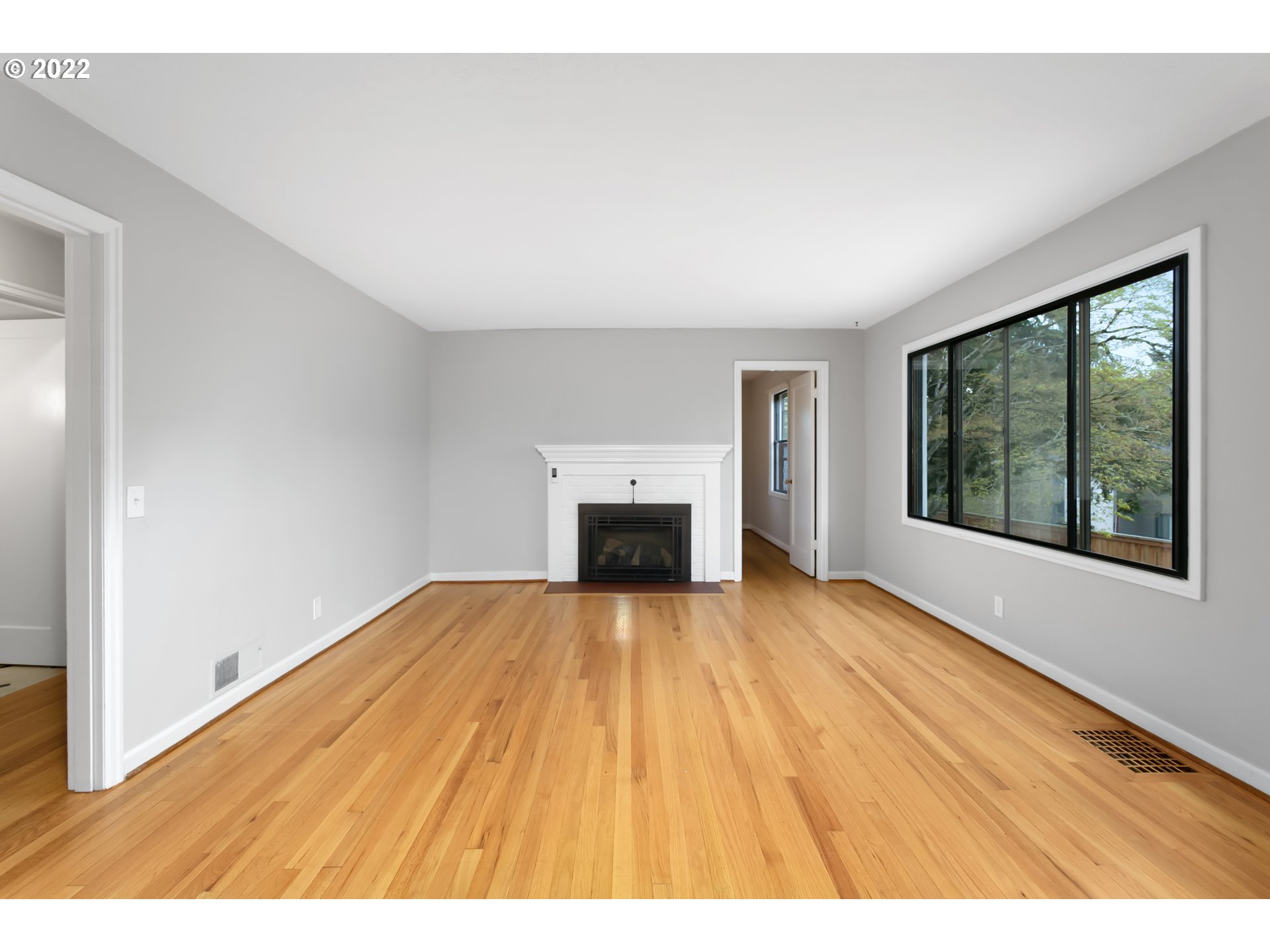 225 Southwest Carson Street Portland, OR 97219 - Photo 5 of 32 a view of empty room with wooden floor and fireplace