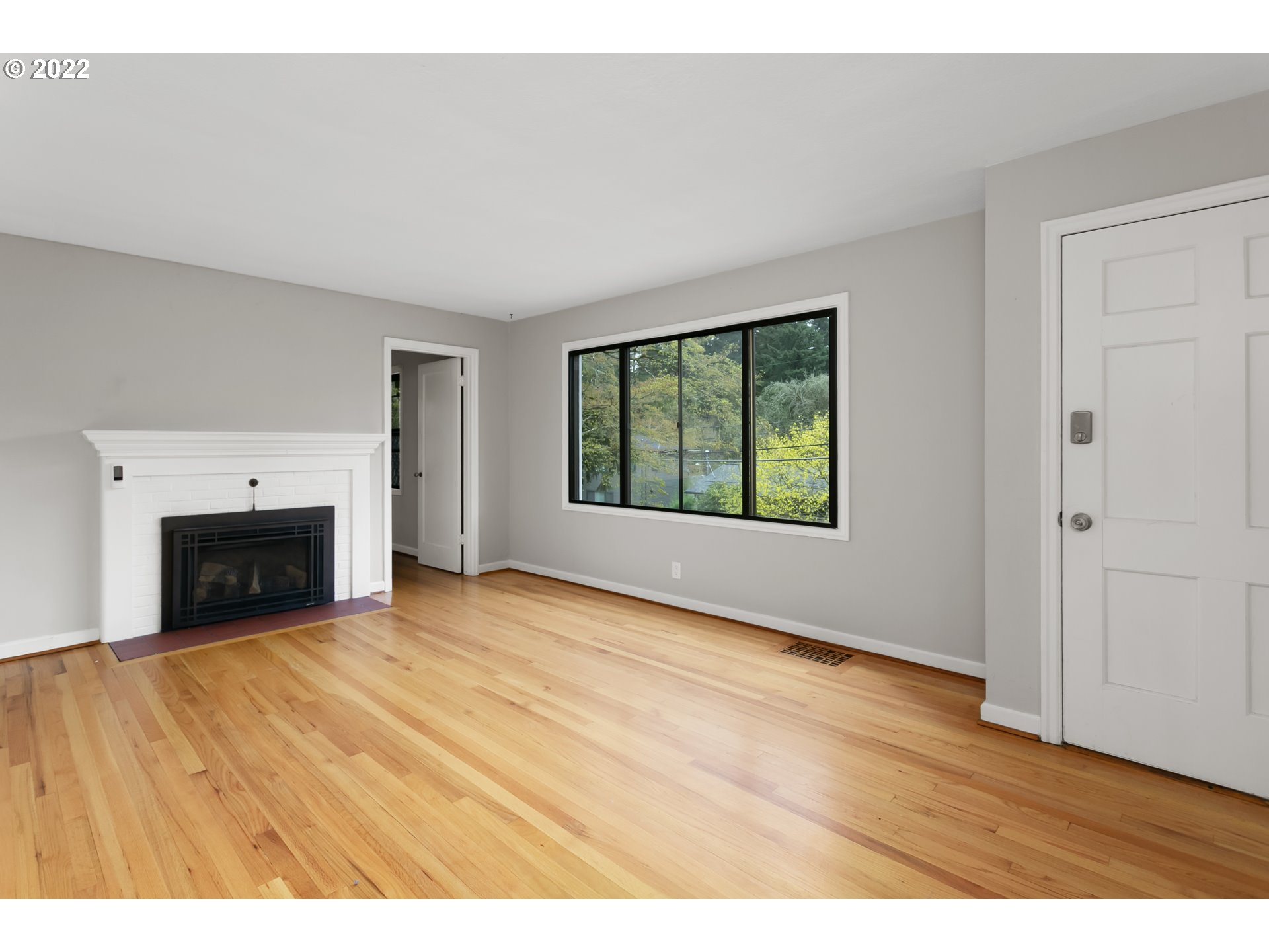 225 Southwest Carson Street Portland, OR 97219 - Photo 6 of 32 an empty room with windows and fireplace