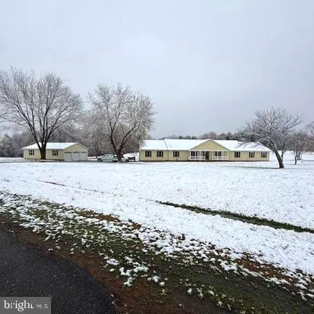 a view of house with snow and trees in the background