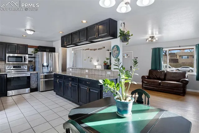 a kitchen with stainless steel appliances granite countertop a refrigerator and a stove top oven