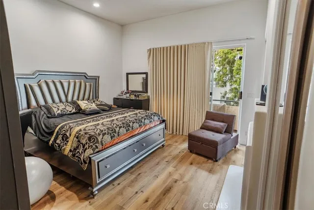 a large white kitchen with stainless steel appliances granite countertop a lot of counter space and wooden floor