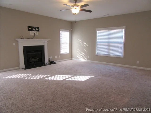 a view of an empty room with a fireplace and a window