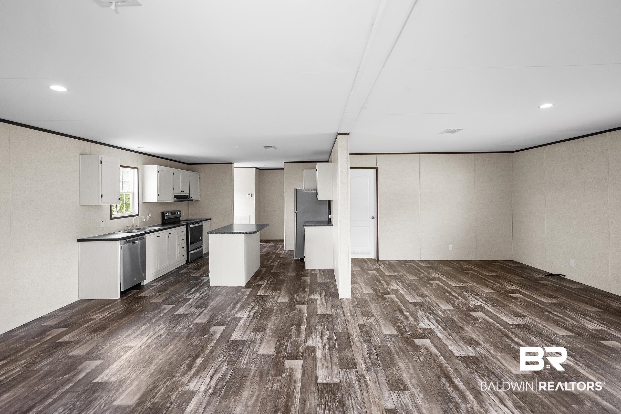 21601 Westside Loop Silverhill, AL 36576 - Photo 13 of 42 Open-concept living space featuring wood-finish flooring, recessed lighting, and a kitchen island with seating