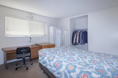 a bedroom with a bed and a desk