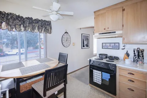 a kitchen with a stove a clock and a table