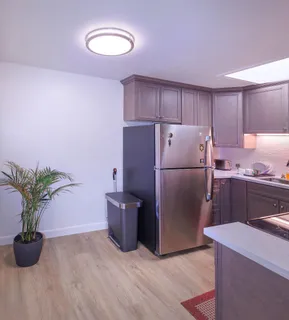 a kitchen with a refrigerator and a white cabinets