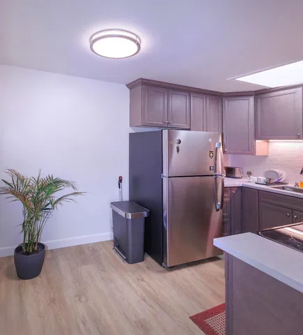 a kitchen with a refrigerator and a white cabinets