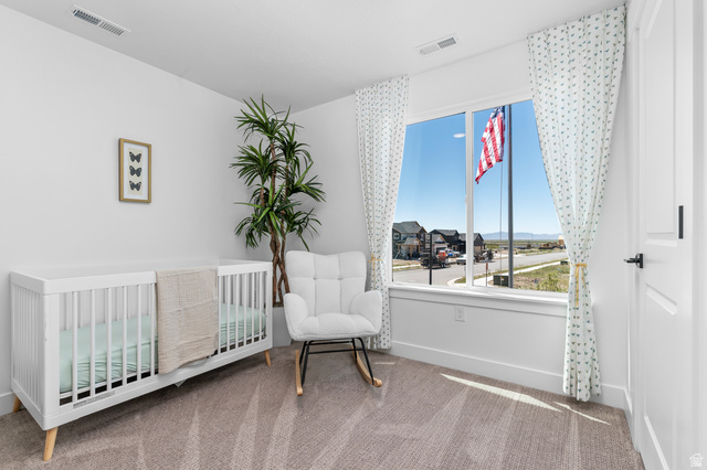 1352 West 2350 South, Unit 18 Perry, UT 84302 - Photo 17 of 26 Bright room featuring neutral carpeting, white walls, and a large window with white trim