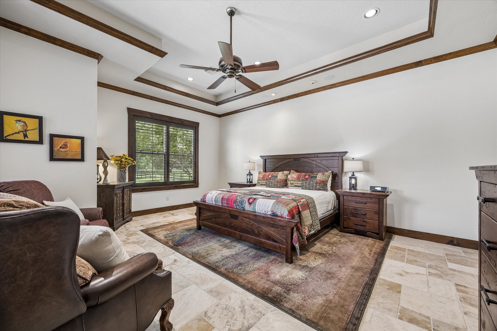 32102 Fulbrook Commons Fulshear, TX 77441 - Photo 17 of 50 The spacious primary suite offers a peaceful retreat with elegant ceiling details and serene views of the surrounding property.
