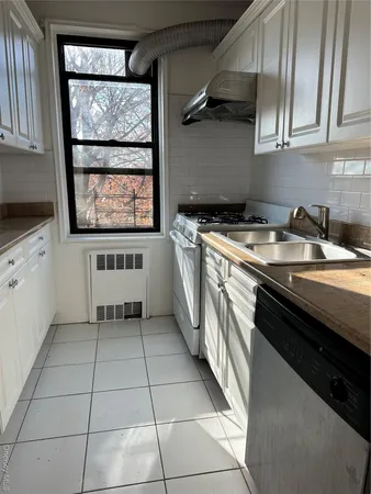 a kitchen with a sink a stove top oven and cabinets