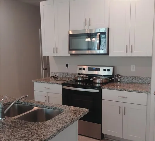 a kitchen with a sink stove and cabinets