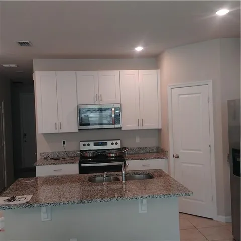 a kitchen with stainless steel appliances granite countertop a stove a microwave and a refrigerator