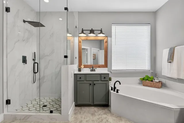 a bathroom with a granite countertop sink a mirror and shower