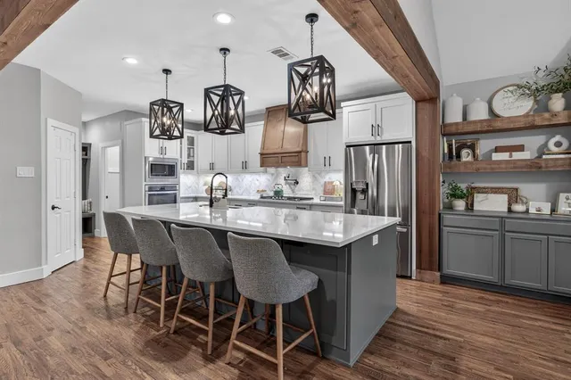 a kitchen with stainless steel appliances granite countertop a kitchen island a stove and a refrigerator