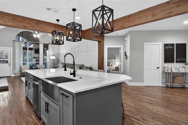 a kitchen with a sink cabinets and wooden floor