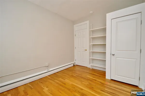 a view of empty room with wooden floor