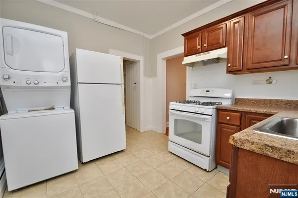 a kitchen with granite countertop white cabinets and white appliances