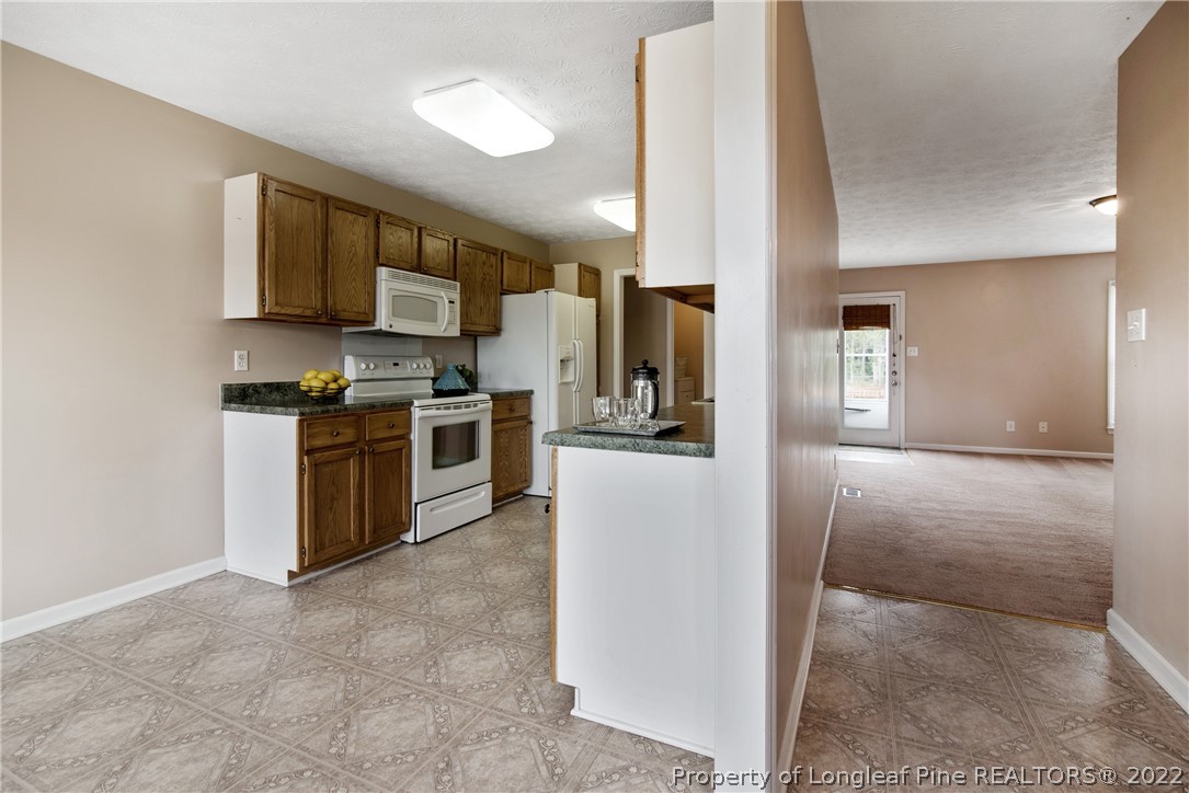 2064 Bainbridge Road Stedman, NC 28391 - Photo 10 of 43 a kitchen with stainless steel appliances granite countertop a stove a sink and a refrigerator